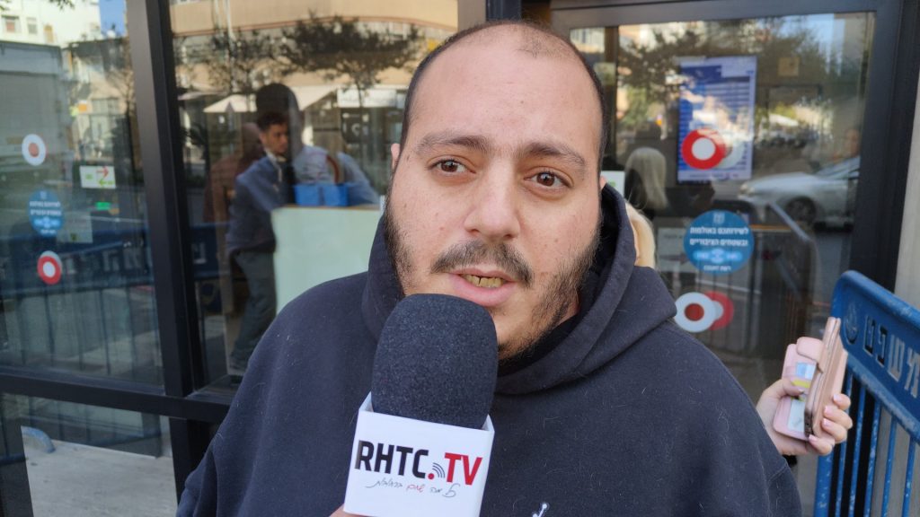 עומרי חיון מתראיין לערוץ RHTC ומאחוריו בית המשפט בתל אביב
